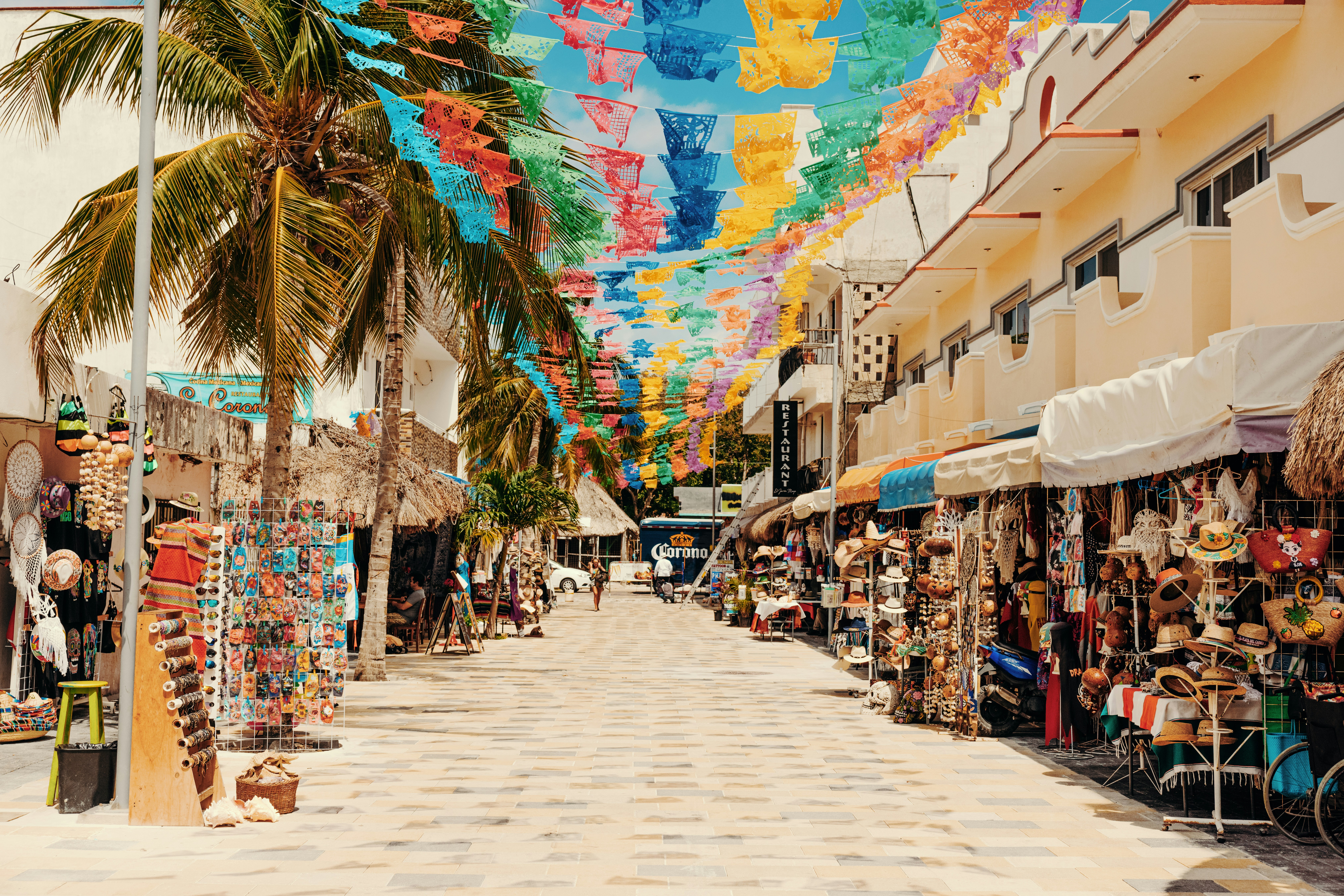 Colorful papel picado over a market street in Playa del Carmen